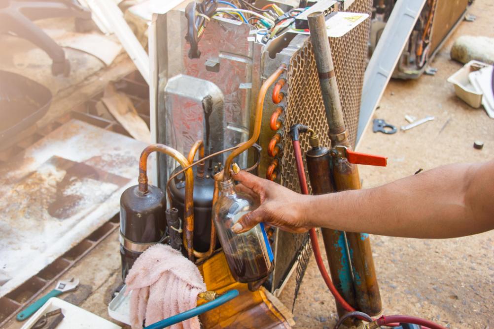 HVAC technician working on air conditioning refrigerant lines