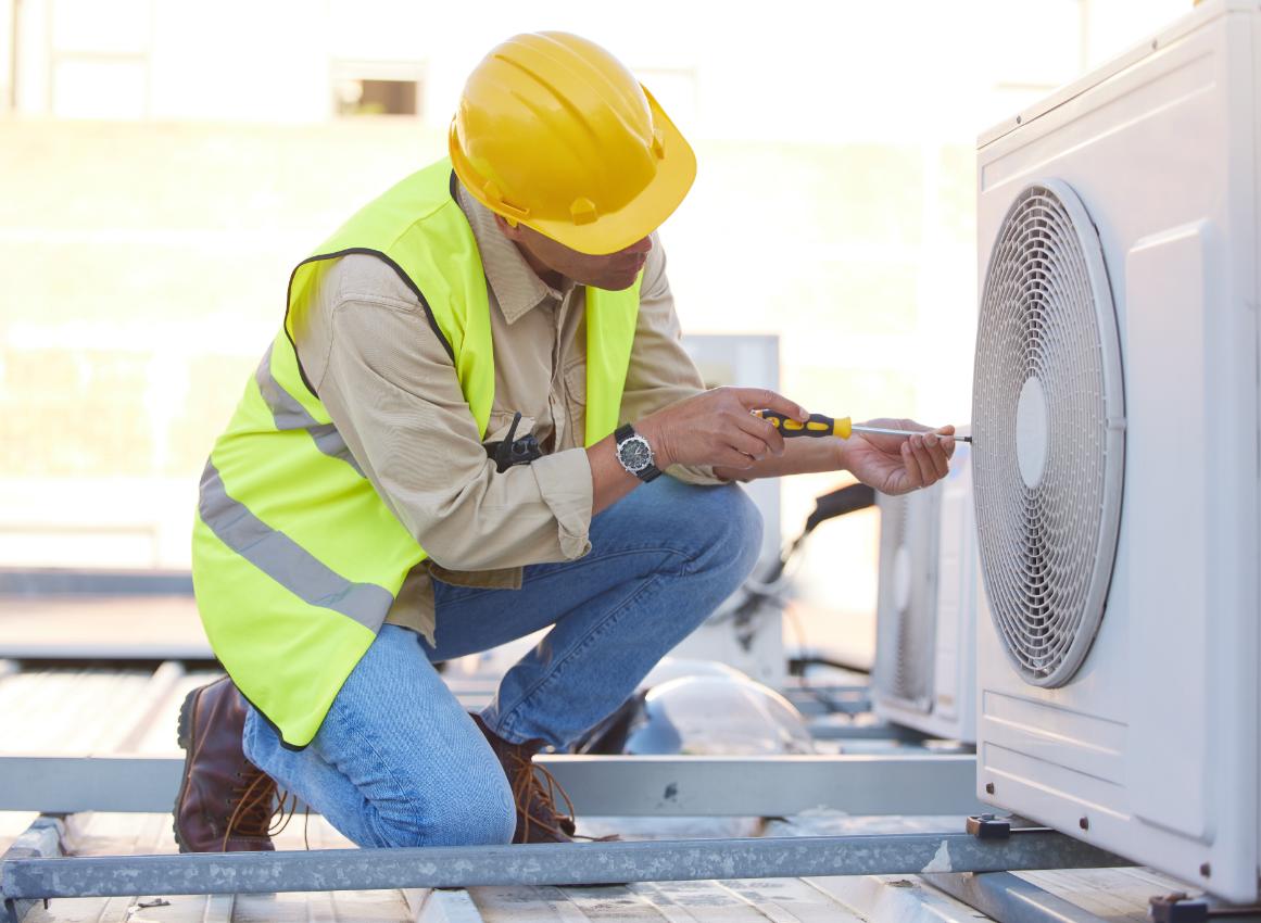 HVAC technician performing rooftop air conditioning unit maintenance