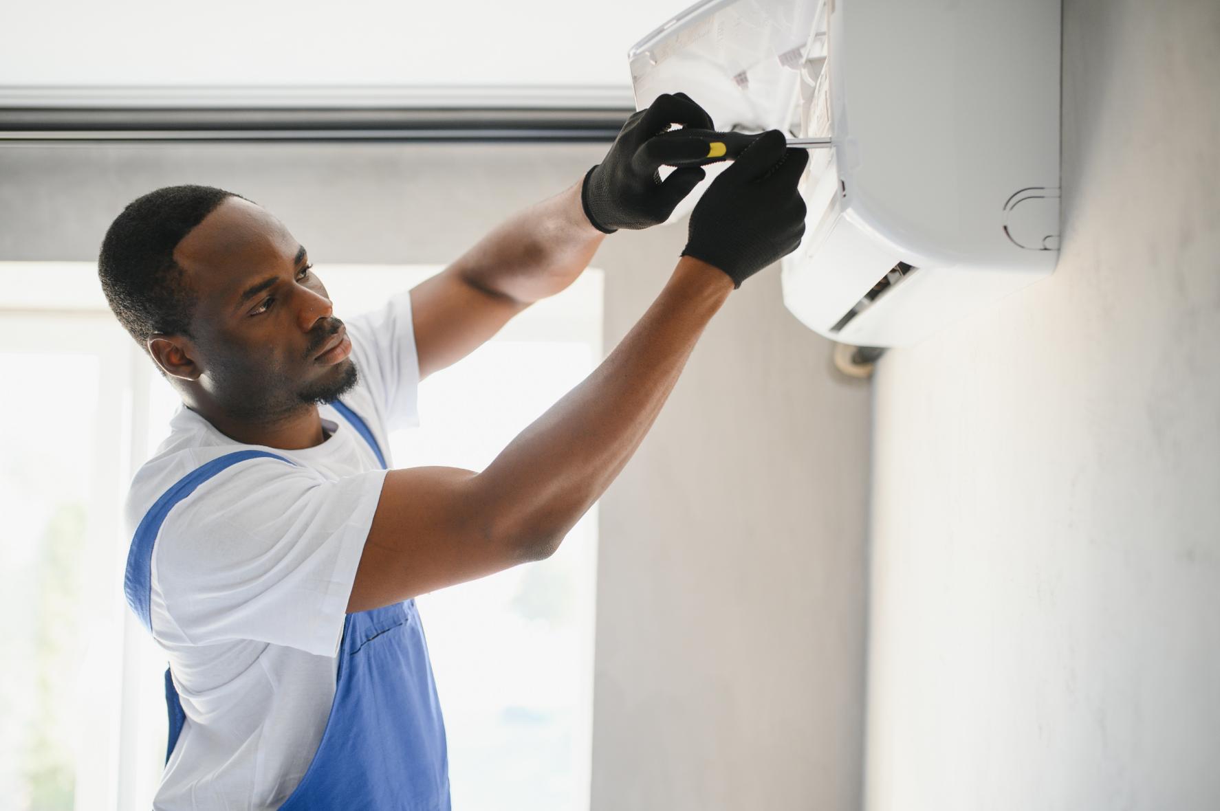 Experienced HVAC technician performing air conditioning unit repair